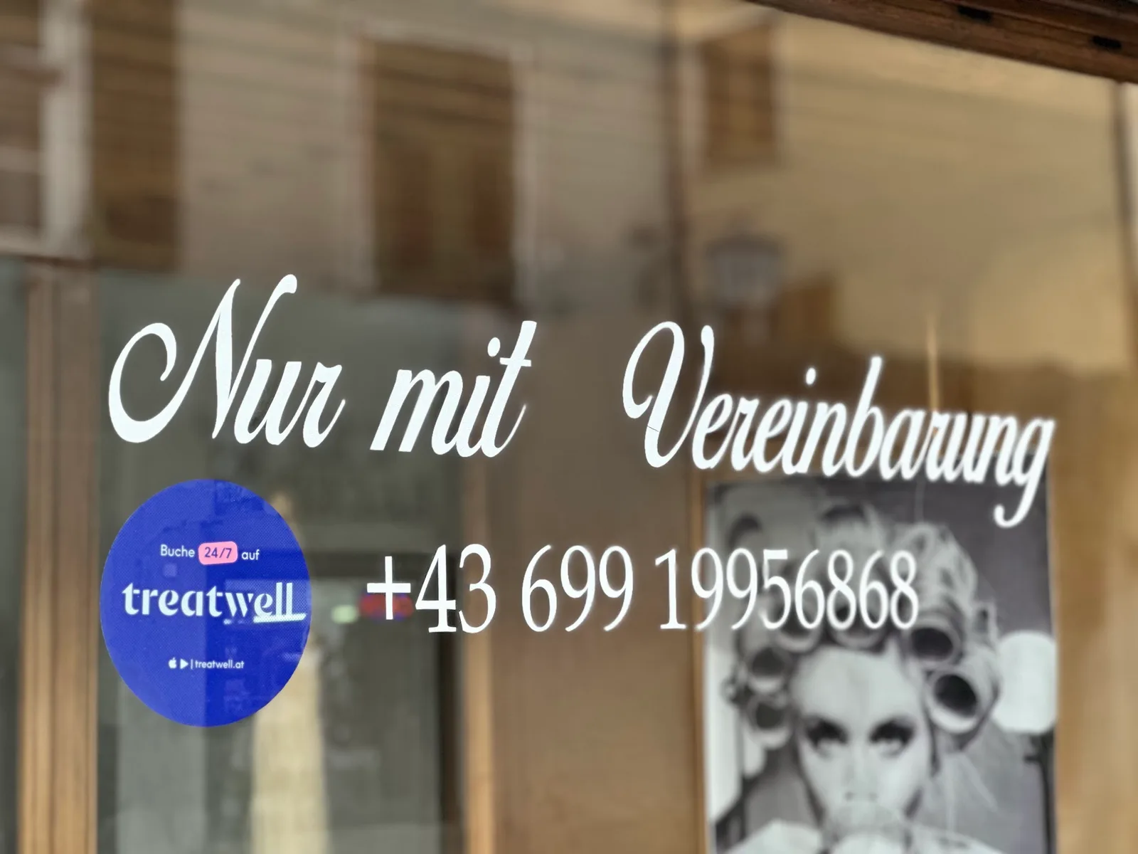 Schaufenster des Salons mit dem Hinweis Nur mit Vereinbarung und der Telefonnummer